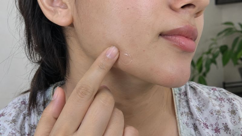 Hand applying a small patch test of a new moisturizer on the inner forearm